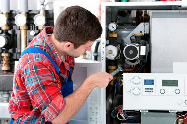 HVAC technician inspecting and repairing boiler controls in North Salt Lake