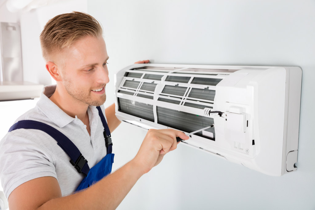 HVAC technician performing ductless air conditioning maintenance in North Salt Lake