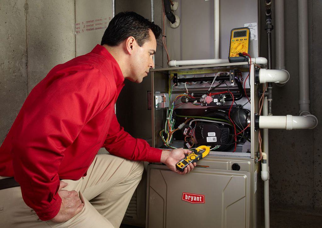 HVAC technician repairing an indoor furnace in North Salt Lake