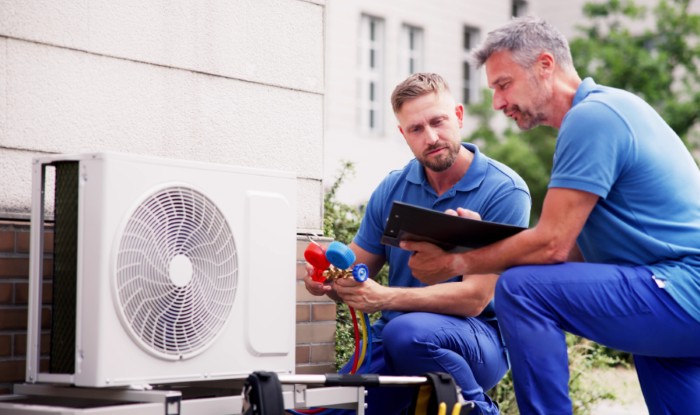 HVAC technicians installing an outdoor air conditioning unit in North Salt Lake