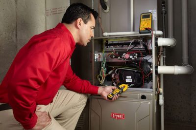furnace repair Heating and air conditioning technician servicing an indoor furnace in North Salt Lake, UT